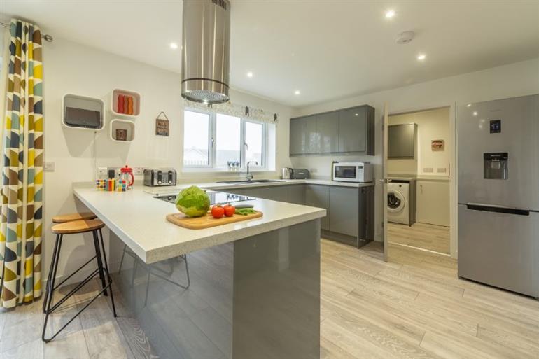Kitchen with high gloss units and breakfast bar at Beacon View, St Agnes in Cornwall