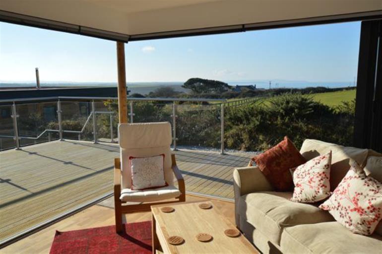 Sitting room with bi-folding doors to deck at Sea Gem,